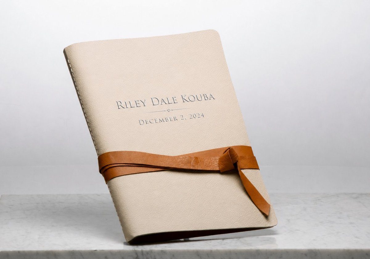 First Light heirloom storybook — leather cover with silver foil debossing and leather tie